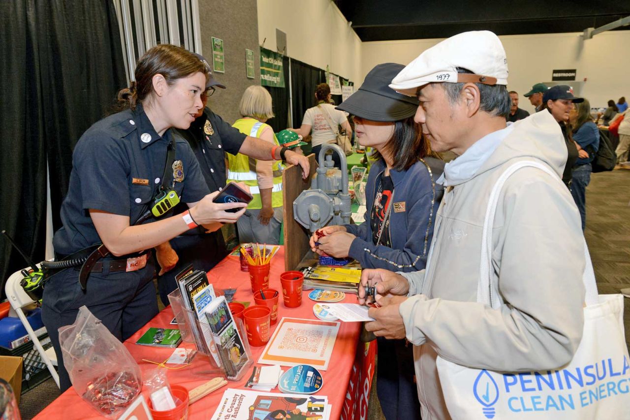 San Mateo County Emergency Management community event booth officer speaks with attendees